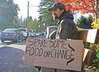 Person with a sign: Spare some food or change